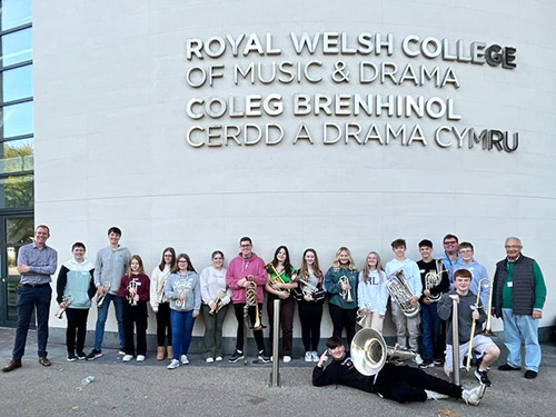 Young musicians standing outside college with their instruments